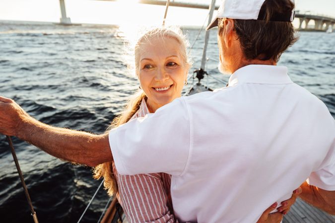 Mature couple on a sailboat at sunset