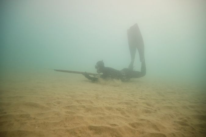 Anonymous man spearfishing in sea water