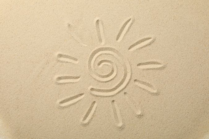Suns drawing on dry sea sand, top view