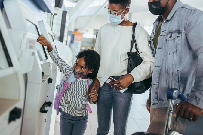 Black couple with cute daughter at airport