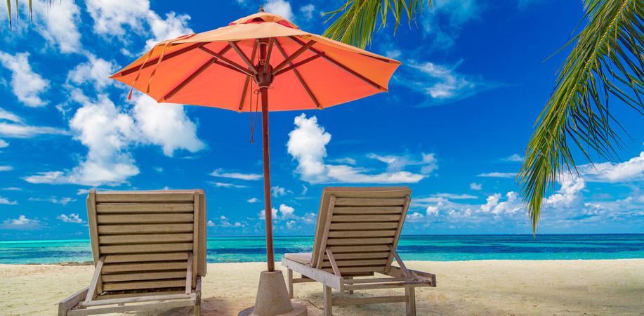 Beach lounge chairs on a tropical island, wide