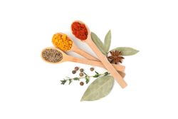 Three wooden spoons full of powder with fresh bay leaf and thyme