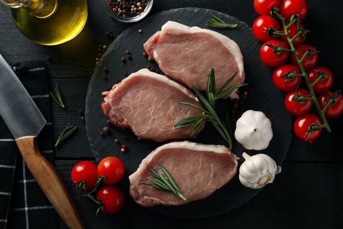 Composition with raw meat for steak and ingredients on wooden background