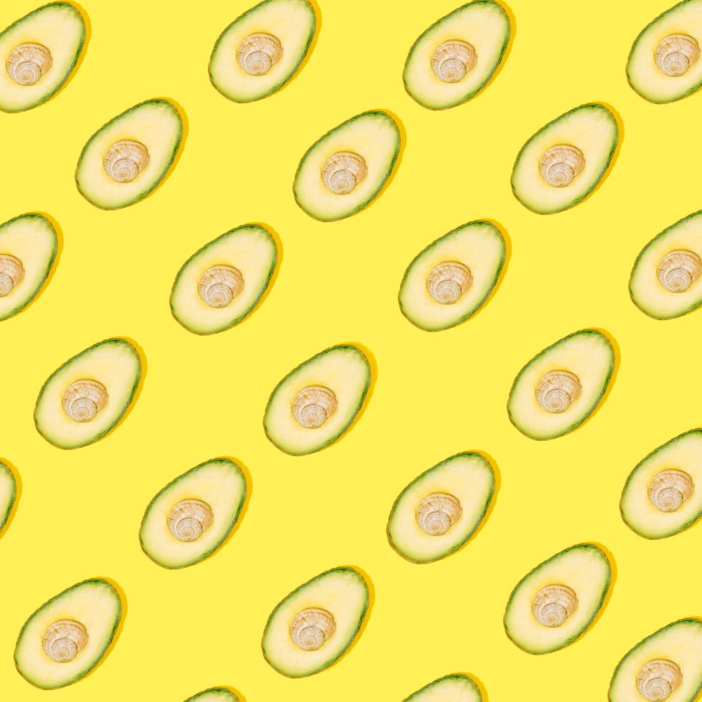 Cut avocado pattern on yellow background