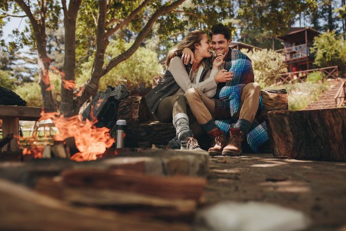 Loving couple relaxing near campfire