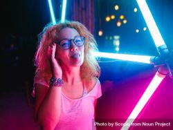 Portrait of woman poking her tongue and standing by neon light 5qLEo0