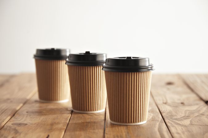 Three to go coffee cups on wooden table