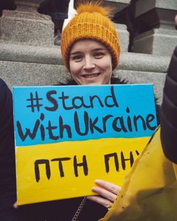 London, England, United Kingdom - March 5 2022: Woman smiling with “Stand with Ukraine” sign