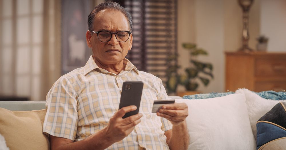 Older Man Using Smartphone and Credit Card:Online Shopping for a Gift to the Lovely Wife