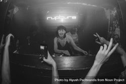 Female DJ spins records at Rupture night club as audience raises hands 4mW870