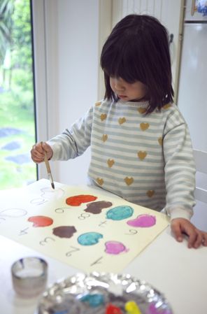 Girl painting and learning numbers