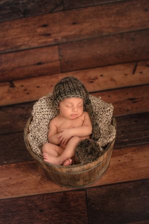 Naked baby sleeping in bucket