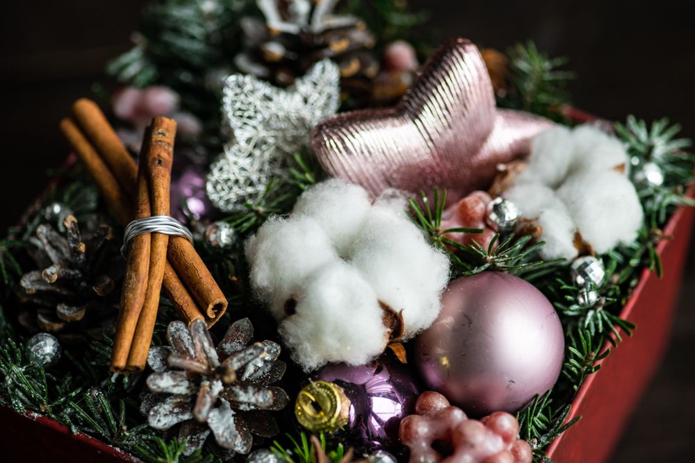 Close up of box of Christmas decorations with baubles, fir tree and cotton heads