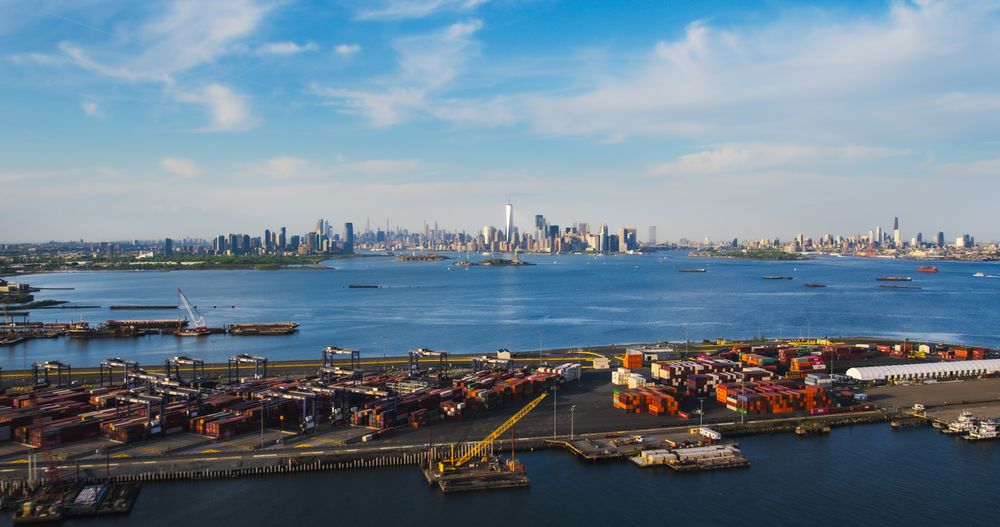 Aerial View of Manhattan Architecture. Panorama of New York City and Jersey City From a Helicopter, Showing Office Buildings and Skyscrapers. Camera Flies Over a Harbour Area with Shipping Containers