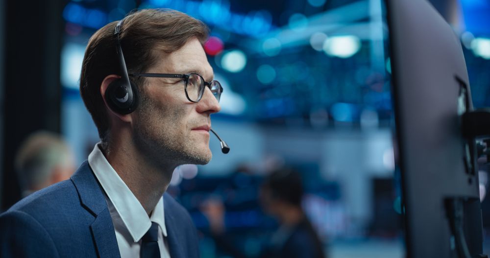 Adult Stock Exchange Broker Working on a Computer with Real-Time Stock Information, Commodities and Exchange Market Charts