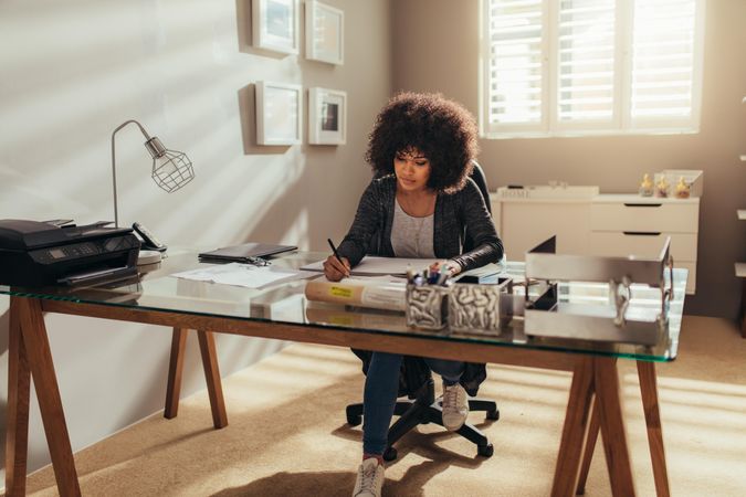 Woman working on new building plans while sitting at her desk