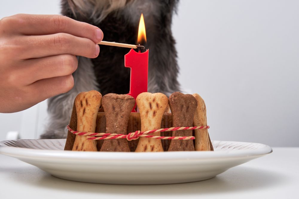 Faceless person with burning candle at table