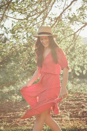 Happy woman in summer dress in park