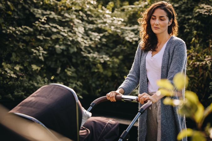 Woman pushing a stroller and looking at her baby