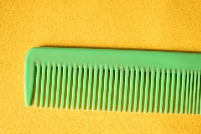 Bright green hair comb in yellow studio