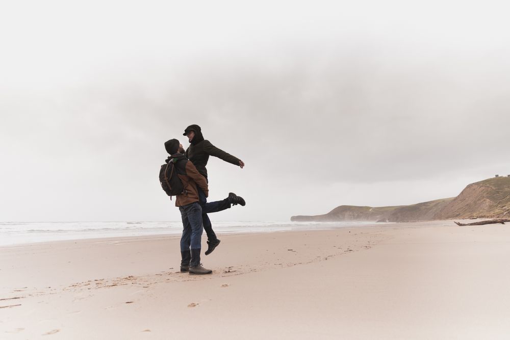 Couple kissing on sand shore near water