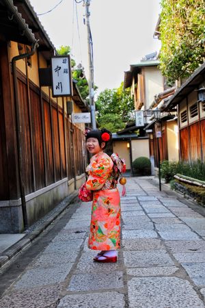 Young girl in kimono standing in an alley