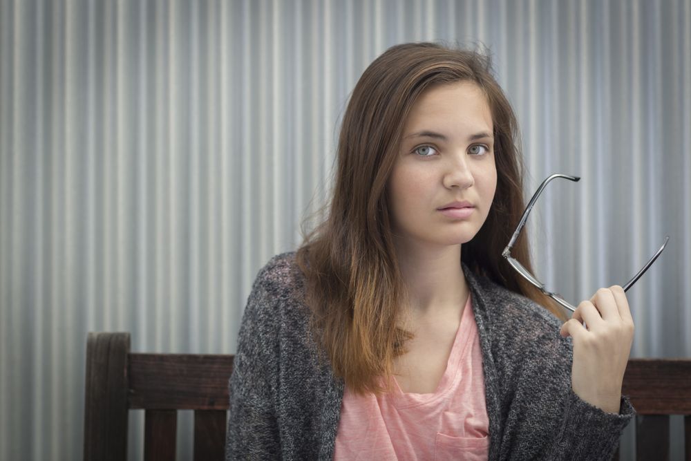 Portrait of Melancholy Young Girl with Glasses