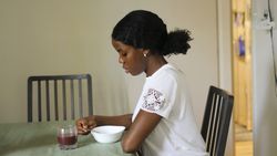 Young Black Female Stirring Muesli in Bowl Before Eating.