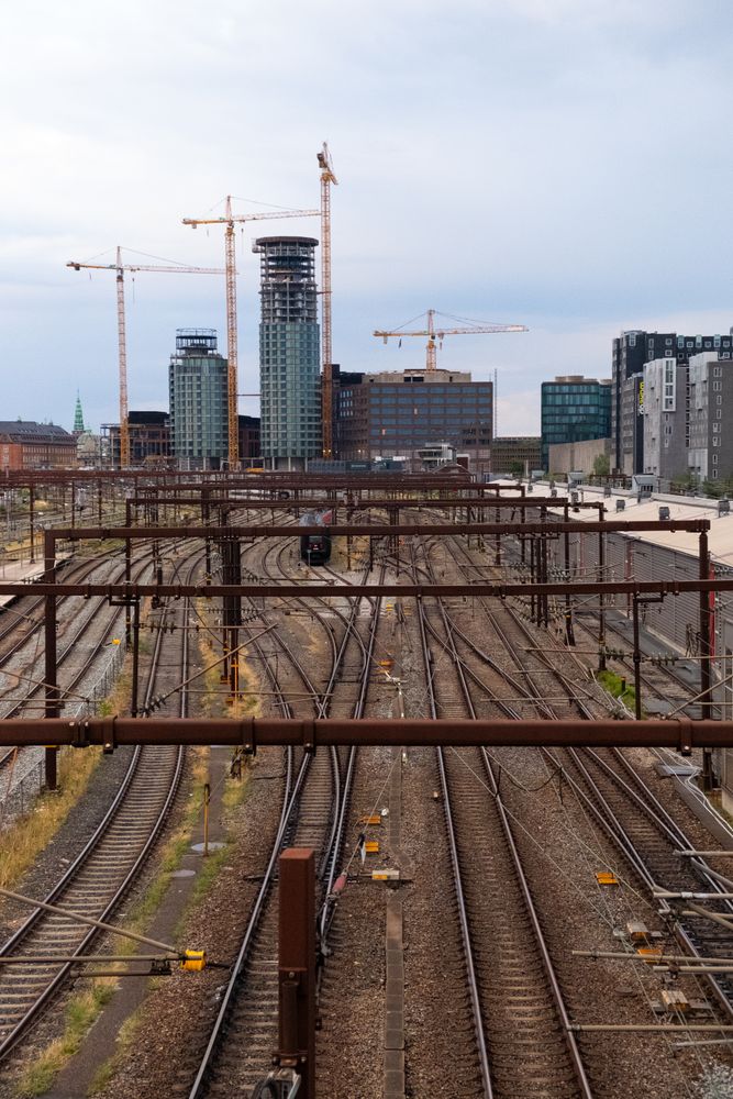 Train tracks with cranes in the background