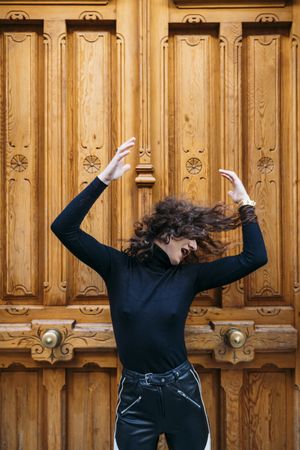 Woman posing in big brown wooden door