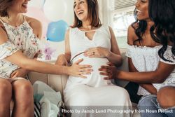 Smiling friends touching tummy of pregnant woman 5r9zwl