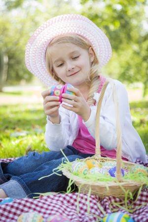 Cute Young Girl Wearing Hat Enjoys Her Easter Eggs