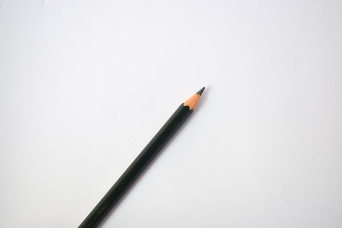 Sharpened pencil in center of table with copy space