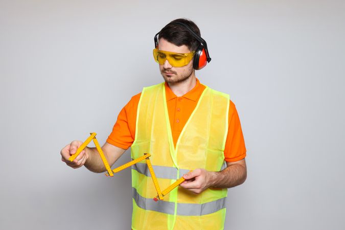 Young man civil engineer in ear protectors and goggles