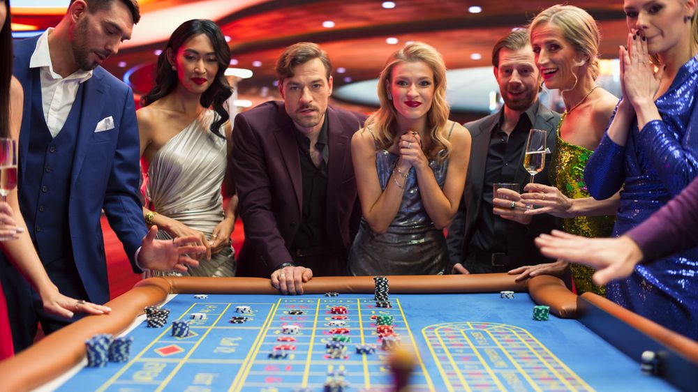 Elegantly Dressed Men and Women Enjoying Luxurious Atmosphere of a Casino.