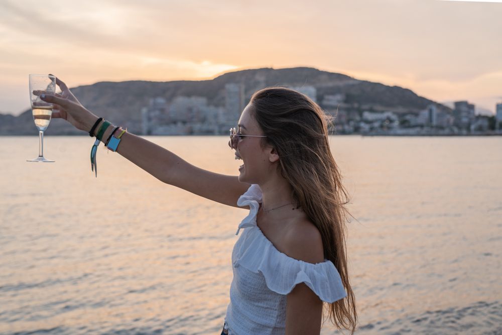 Young woman enjoying wine near sea