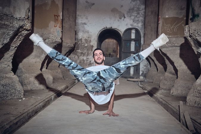 Man dancing break dance in abandoned building