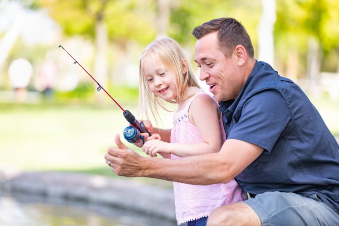 Young Father and Daughter Having Fun Fishing At The Lake