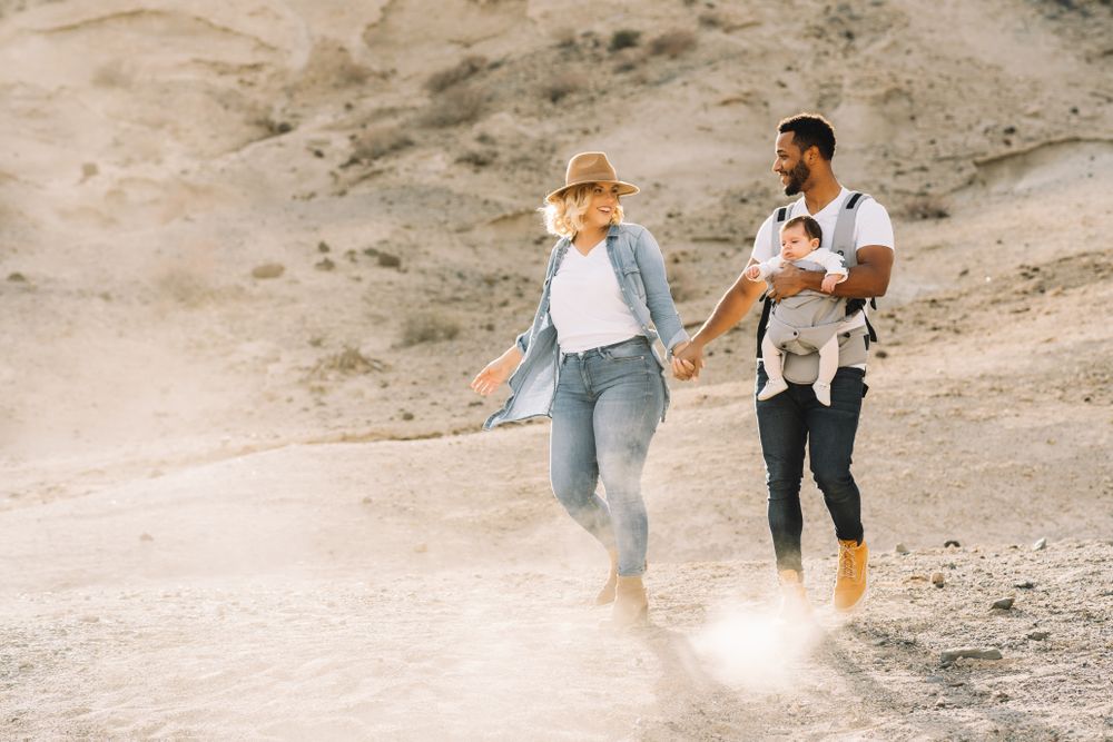 Diverse parents dancing while walking with baby