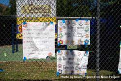 Three homemade signs from teachers to their students taped to chainlink fence at school 5lVJYb