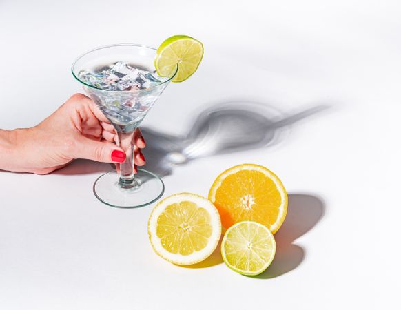 Cocktail glass with ice cubes and sliced citrus