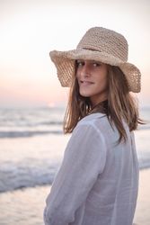 Charming woman in light white dress on wavy beach