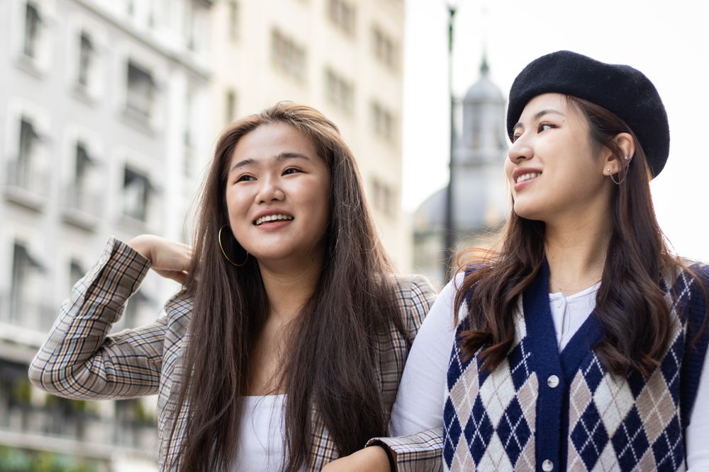 Asian female friends walking on the street in the city