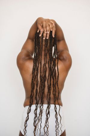 Back view of Black topless woman with braided hair