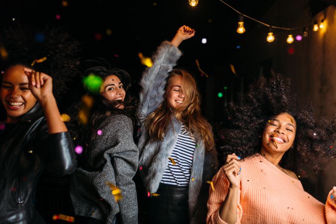 Multi-ethnic group of female friends dancing at party outside