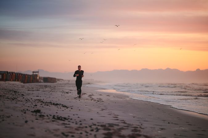 Fitness man jogging on the sea shore