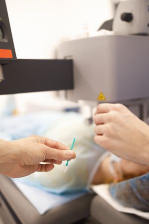 Surgeons passing tools in operating theater