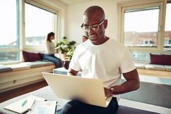 Content businessman working on his laptop in a bright office