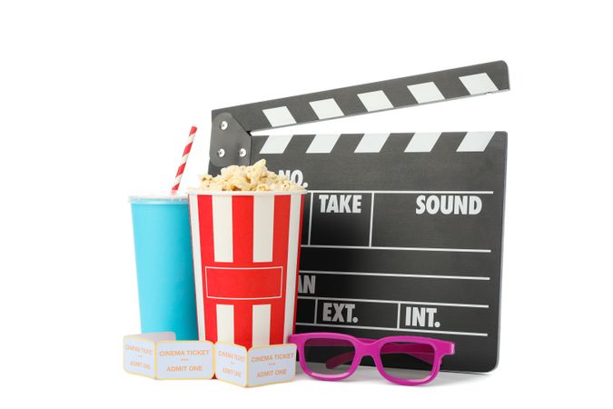 Clapperboard, paper cup, bucket with popcorn, tickets and 3d glasses isolated on studio background