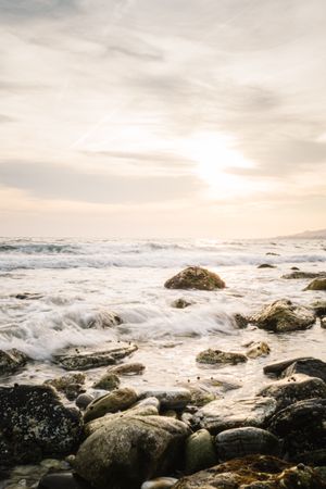 Stony seashore and waves at beautiful sunset